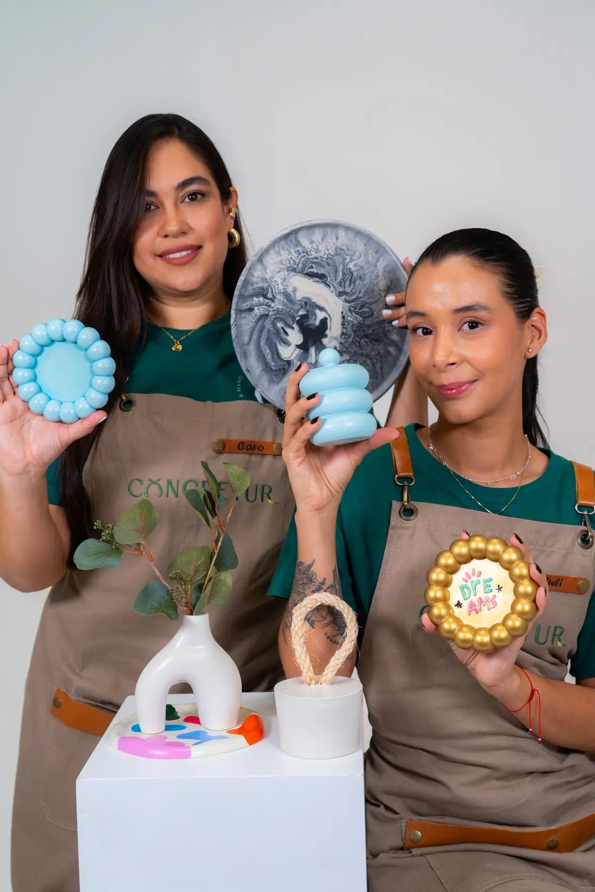 Profesoras del curso mostrando piezas decorativas en concreto